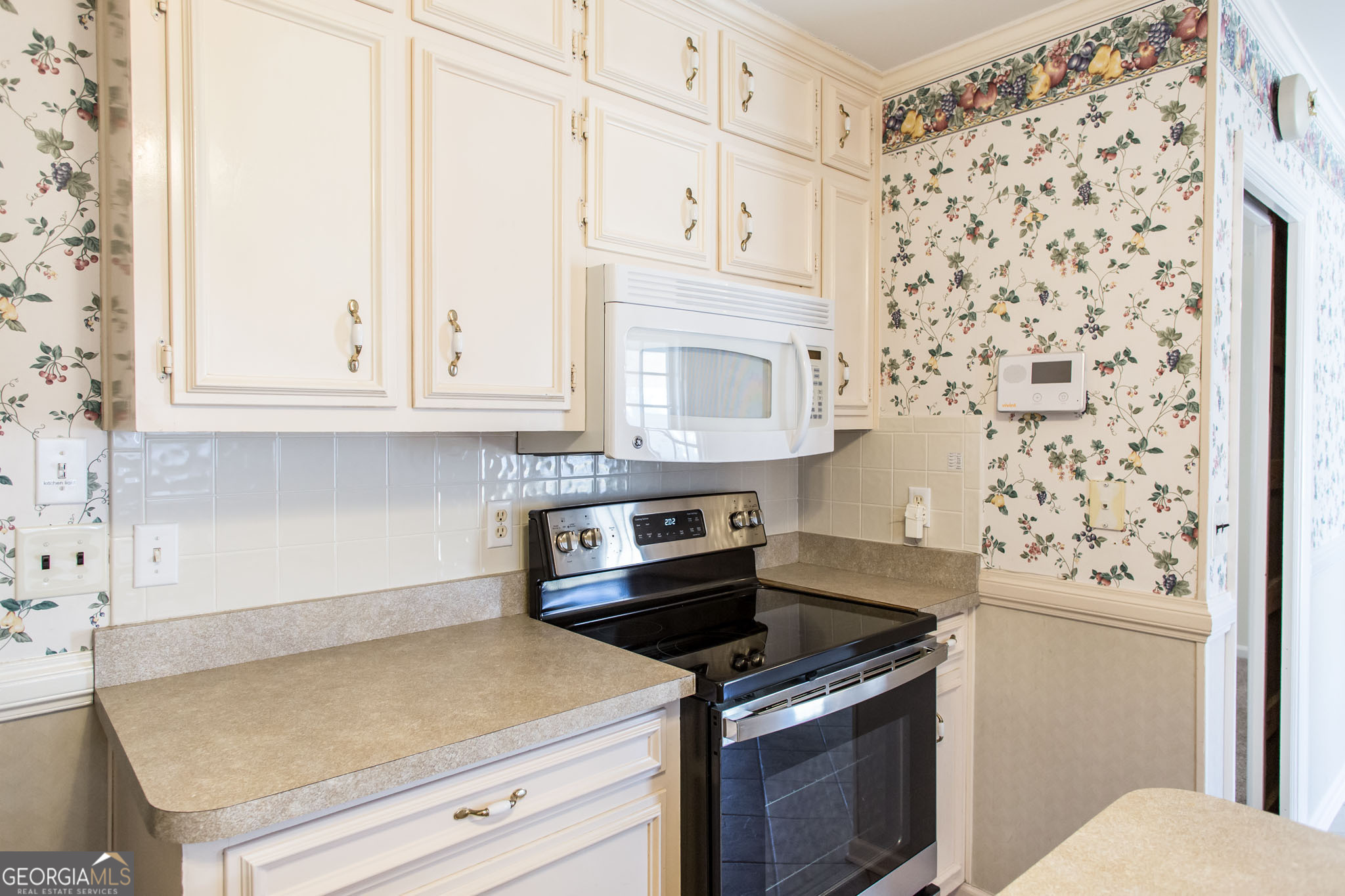 402 Preston Street Waycross, GA 31501 - Photo 18 of 43 a kitchen with granite countertop white cabinets and white appliances