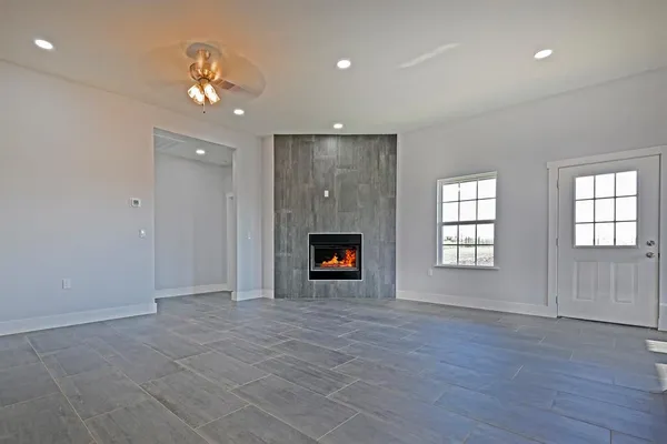 an empty room with wooden floor and chandelier