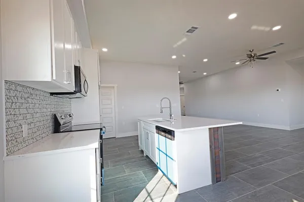 a kitchen with stainless steel appliances a sink stove and cabinets