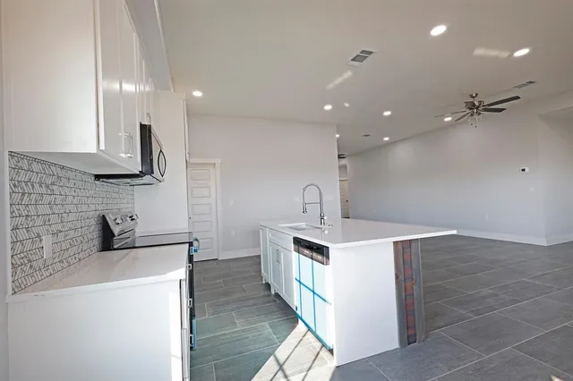 a kitchen with stainless steel appliances a sink stove and cabinets