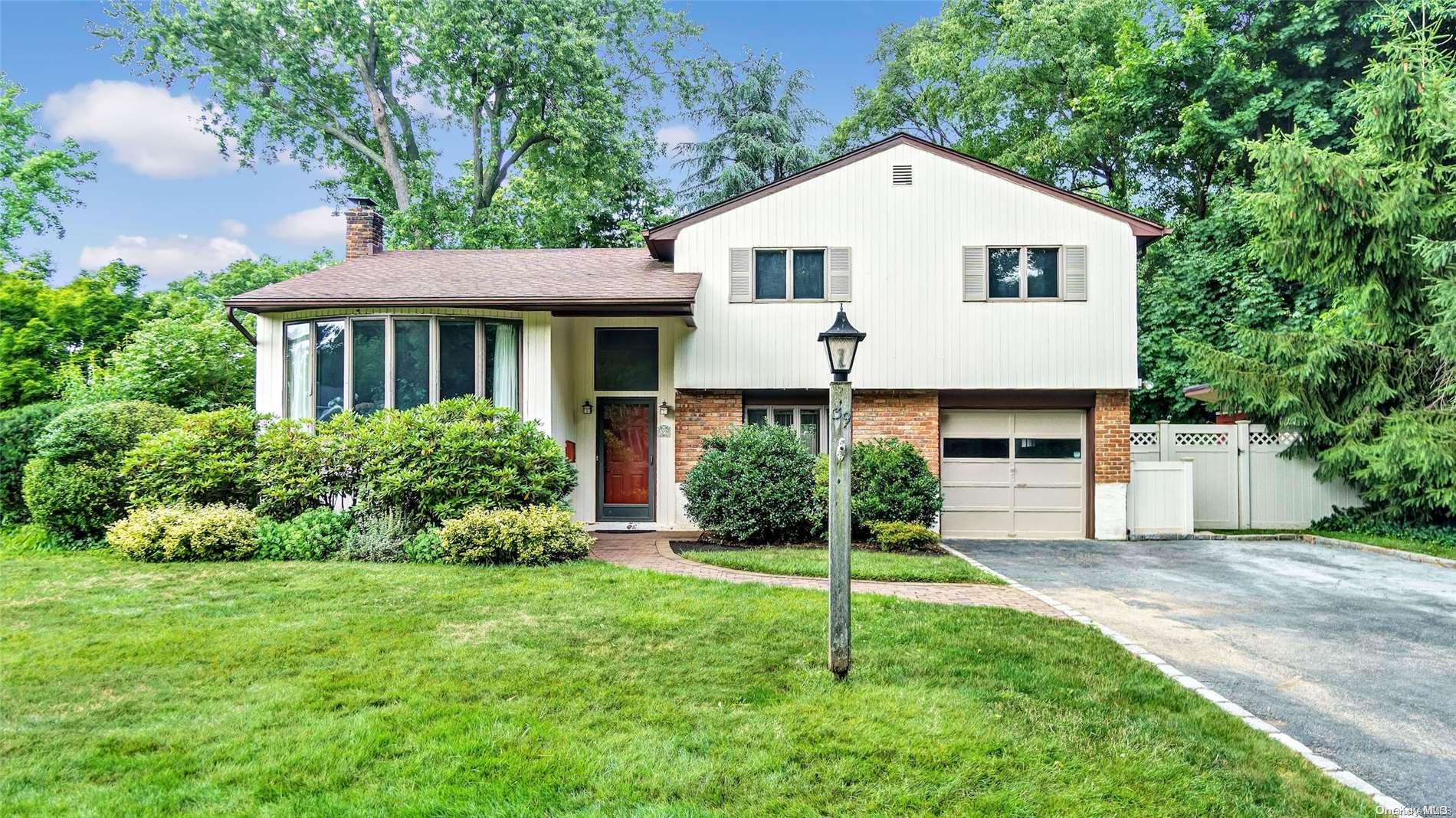 39 Daniel Drive Glen Cove, NY 11542 - Photo 1 of 1 a view of a white house next to a yard with potted plants