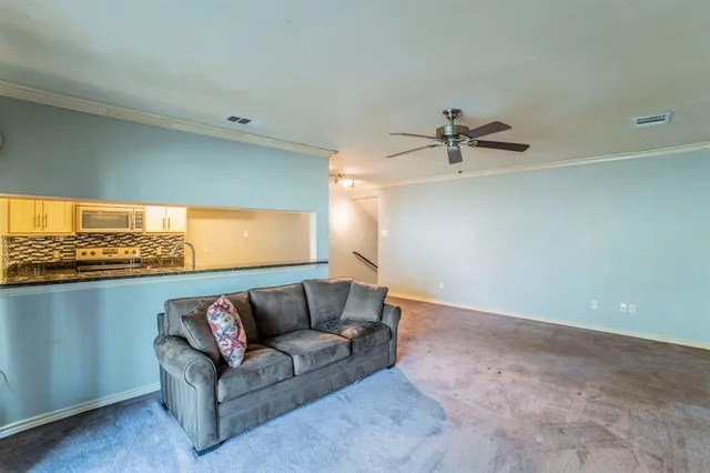 a living room with furniture and a ceiling fan