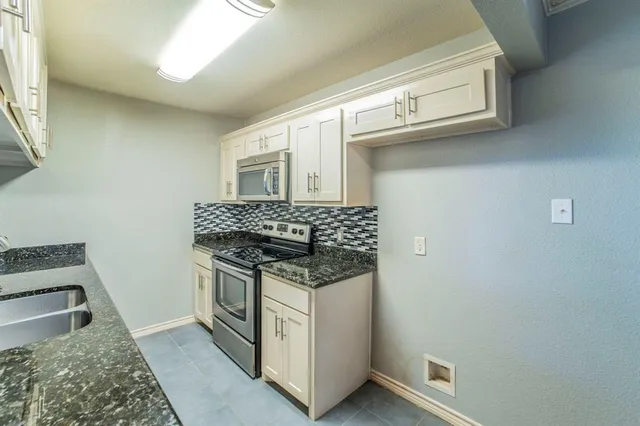 a kitchen with stainless steel appliances granite countertop a stove and a sink