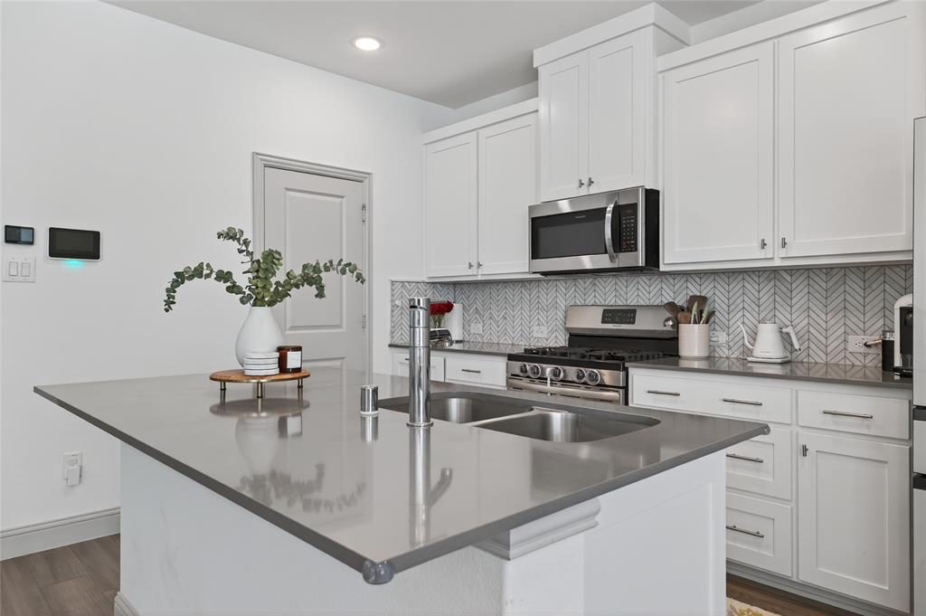 9000 Phoebe Road Frisco, TX 75035 - Photo 11 of 27 a kitchen with stainless steel appliances granite countertop a sink a stove and a microwave