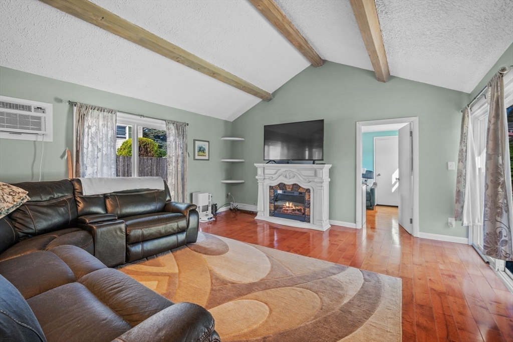 1 Reed Road Peabody, MA 01960 - Photo 14 of 31 a living room with furniture a fireplace and a flat screen tv