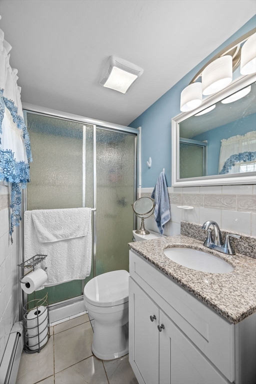 1 Reed Road Peabody, MA 01960 - Photo 17 of 31 a bathroom with a granite countertop toilet a sink and a mirror