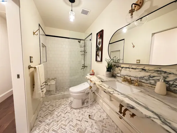 a bathroom with a sink toilet a mirror and shower