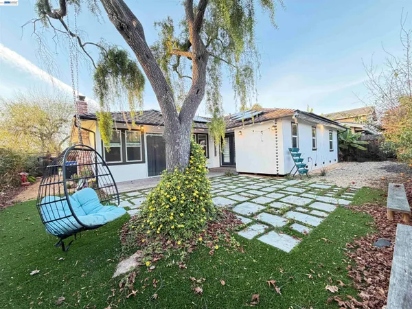 a view of a house with backyard and sitting area