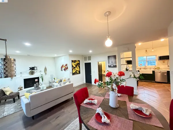 a living room with furniture kitchen view and a chandelier