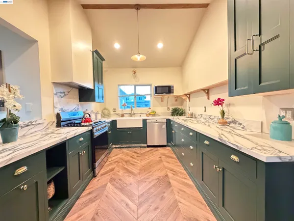 a kitchen with kitchen island granite countertop a sink stainless steel appliances and cabinets