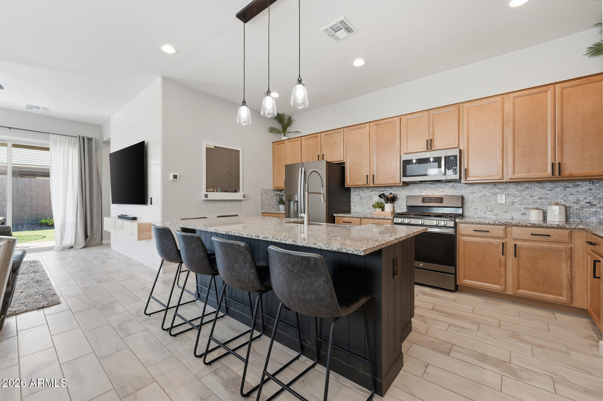 23069 East Mayberry Road Queen Creek, AZ 85142 - Photo 7 of 48 a kitchen with stainless steel appliances a table chairs sink and cabinets