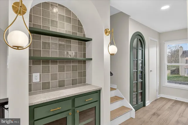 a kitchen with stainless steel appliances granite countertop a refrigerator a stove and a sink with wooden floor