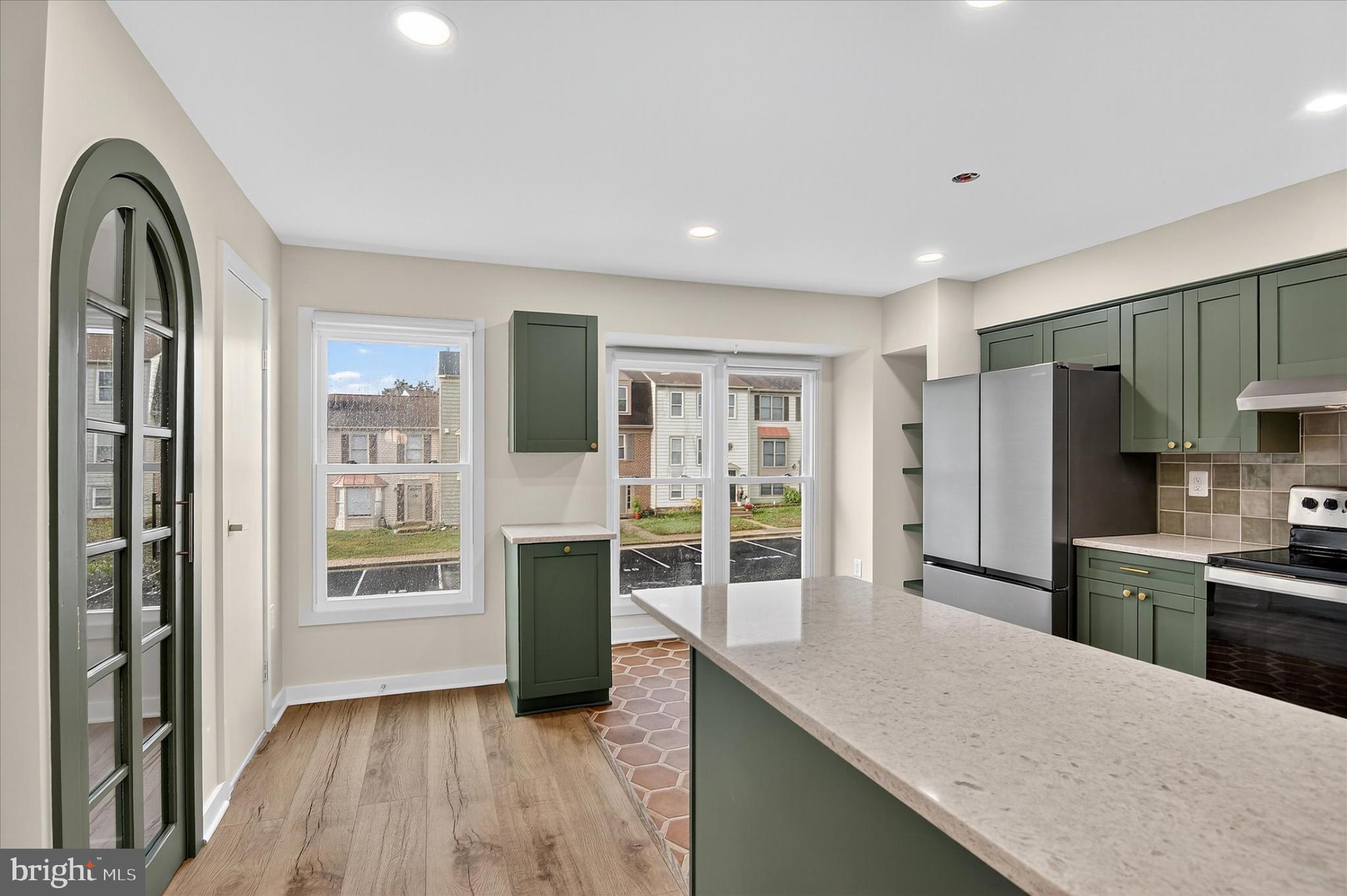 10502 Oronoco Lane Manassas, VA 20109 - Photo 19 of 37 a kitchen with stainless steel appliances granite countertop a refrigerator a stove and a sink with wooden floor