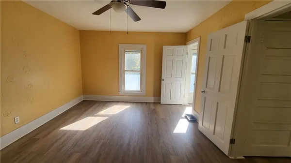 a view of a livingroom with wooden floor and a ceiling fan