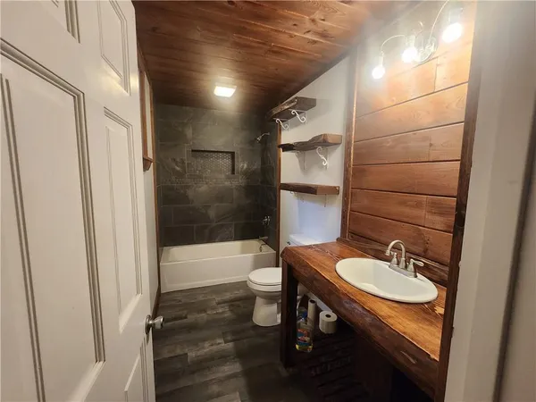 a bathroom with a sink a toilet a mirror and shower