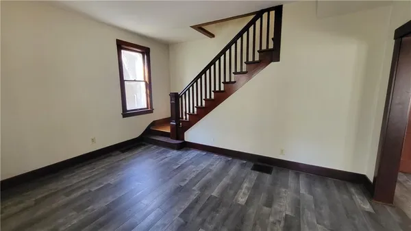 a view of a hallway with wooden floor and staircase