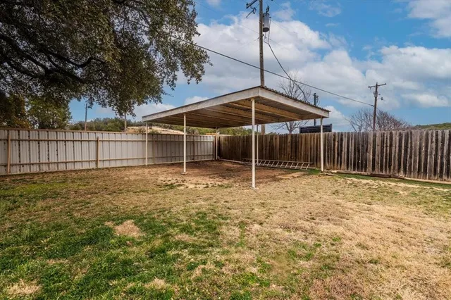 a backyard of a house with table and chairs