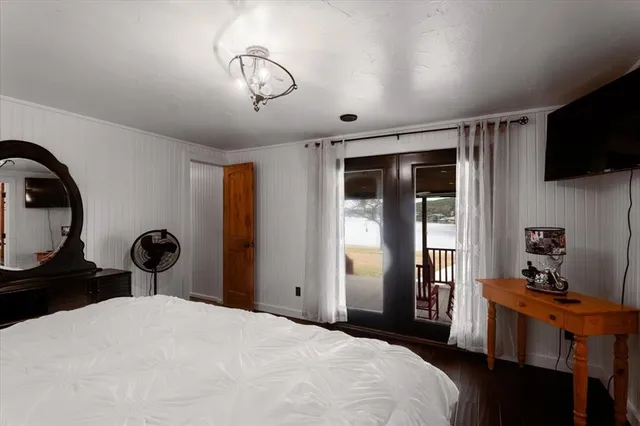 a bedroom with a bed and a flat tv screen on the dresser