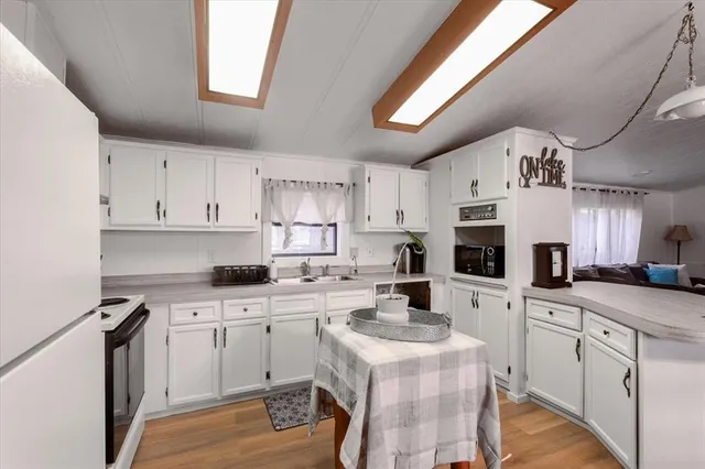a kitchen with white cabinets sink and white appliances