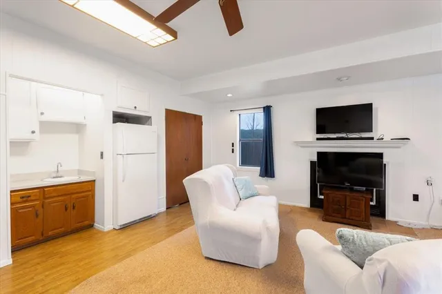 a living room with furniture a flat screen tv and a fireplace