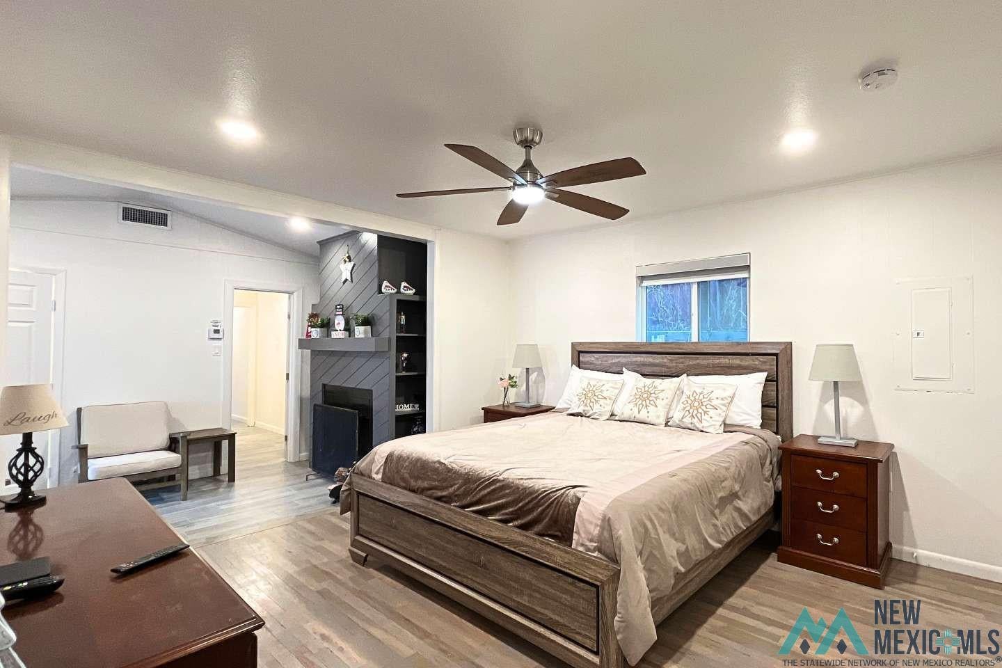 241 Junction Road Ruidoso, NM 88345 - Photo 12 of 44 Bedroom with wood finished floors, ceiling fan, electric panel, and lofted ceiling