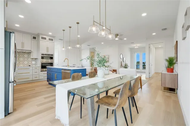 a view of a dining room and livingroom with furniture wooden floor a chandelier
