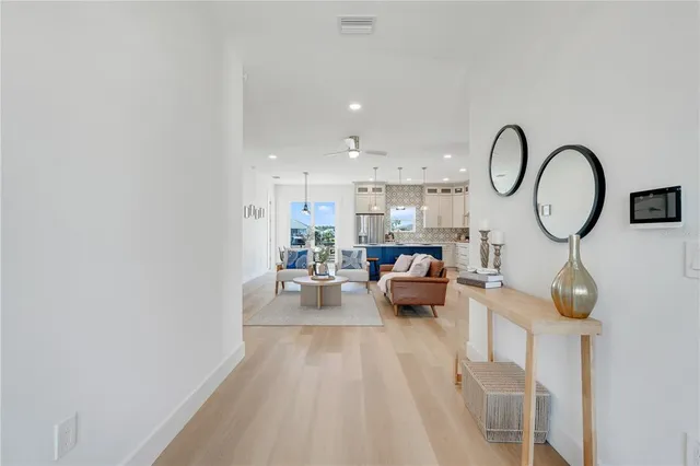 a living room with furniture a mirror and a wooden floor