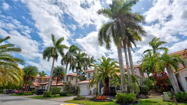 a front view of multi story residential apartment building with yard and green space