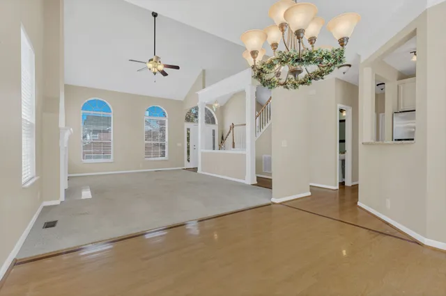 an empty room with windows and chandelier