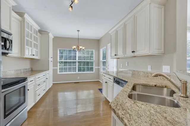 a kitchen with granite countertop a sink and a stove top oven