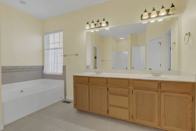 a bathroom with a tub sink and mirror