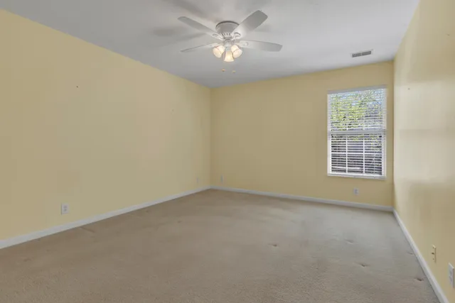 an empty room with a window and a ceiling fan