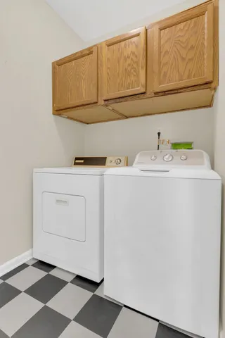 a utility room with cabinets washer and dryer