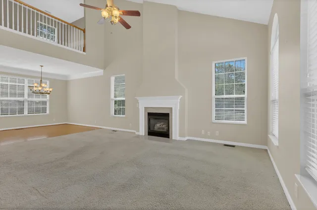 a view of an empty room with a window and fireplace