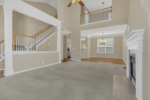 a view of an empty room with a window and fireplace