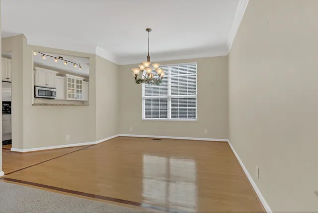 an empty room with windows and chandelier