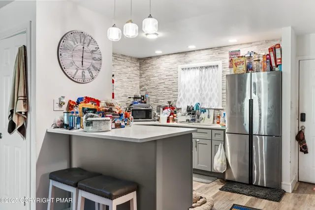 a kitchen with stainless steel appliances a sink a chandelier a refrigerator and a chandelier