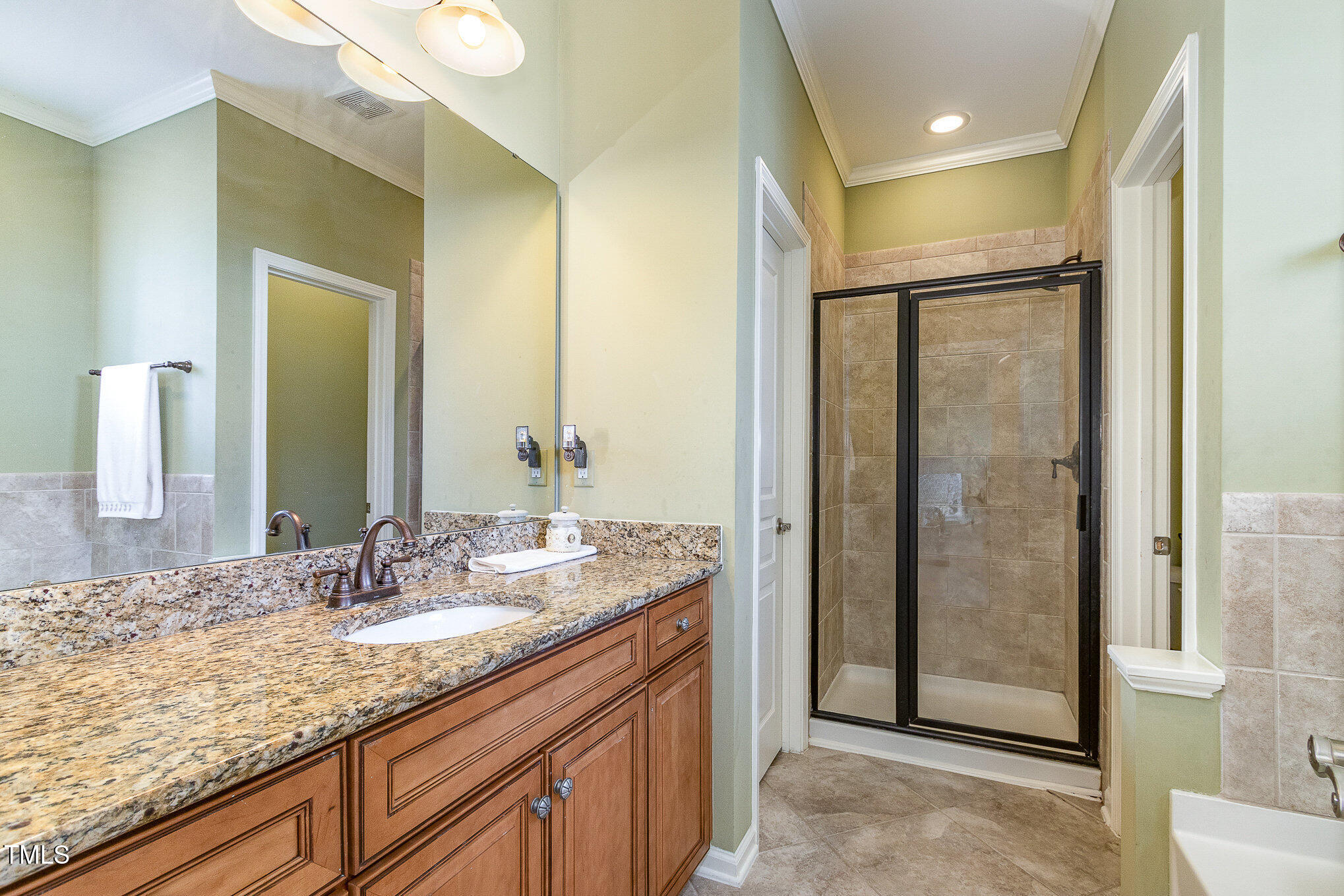 9207 Wooden Road Raleigh, NC 27617 - Photo 20 of 27 a bathroom with a granite countertop sink mirror and shower