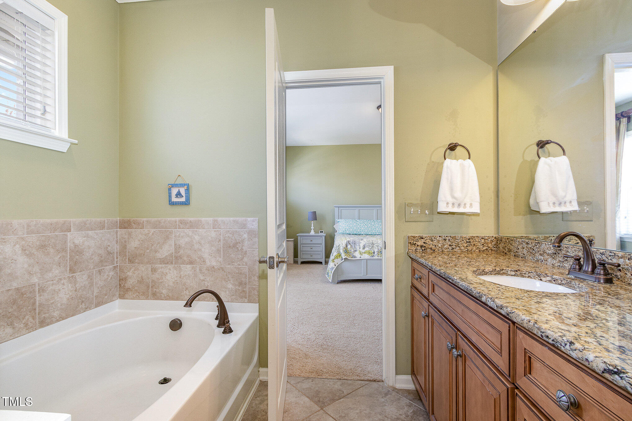 9207 Wooden Road Raleigh, NC 27617 - Photo 21 of 27 a en suite bathroom with a granite countertop tub sink and mirror