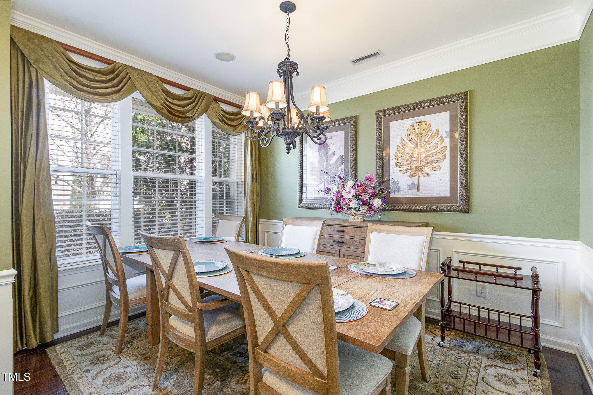 9207 Wooden Road Raleigh, NC 27617 - Photo 7 of 27 a dining room with furniture a chandelier and a rug