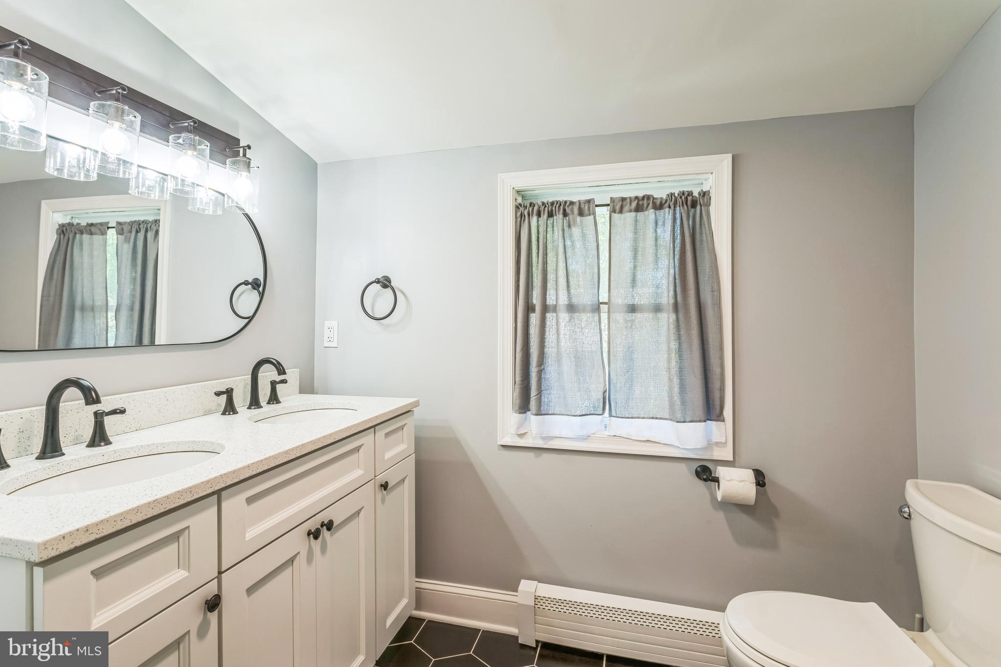 414 Delaware Avenue Croydon, PA 19021 - Photo 23 of 34 a bathroom with a toilet a sink a mirror a window and vanity