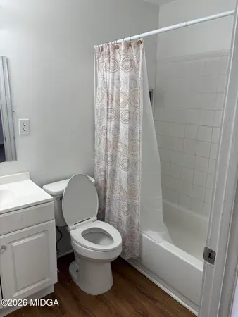 a white toilet sitting next to a bath tub