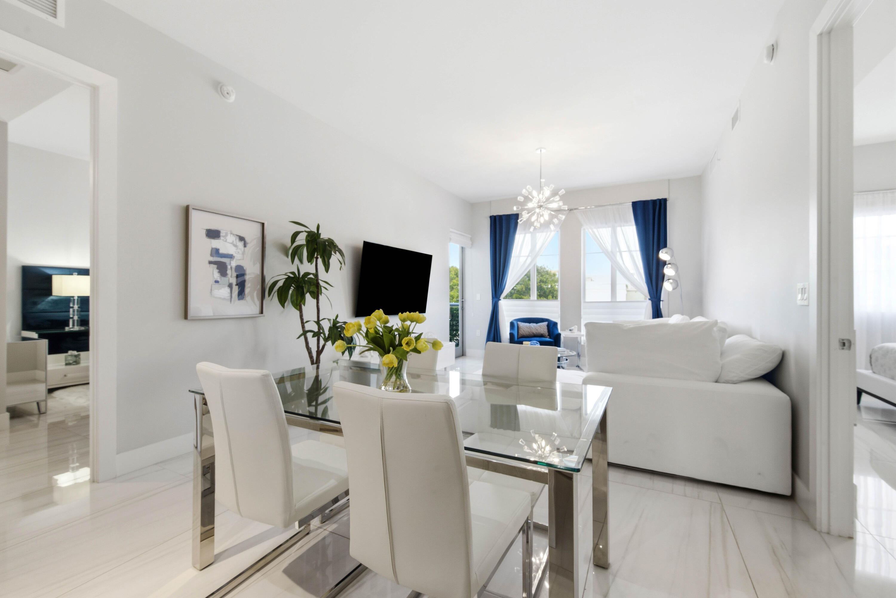 155 East Boca Raton Road, Unit 313 Boca Raton, FL 33432 - Photo 11 of 72 a living room with furniture a flat screen tv and a large window