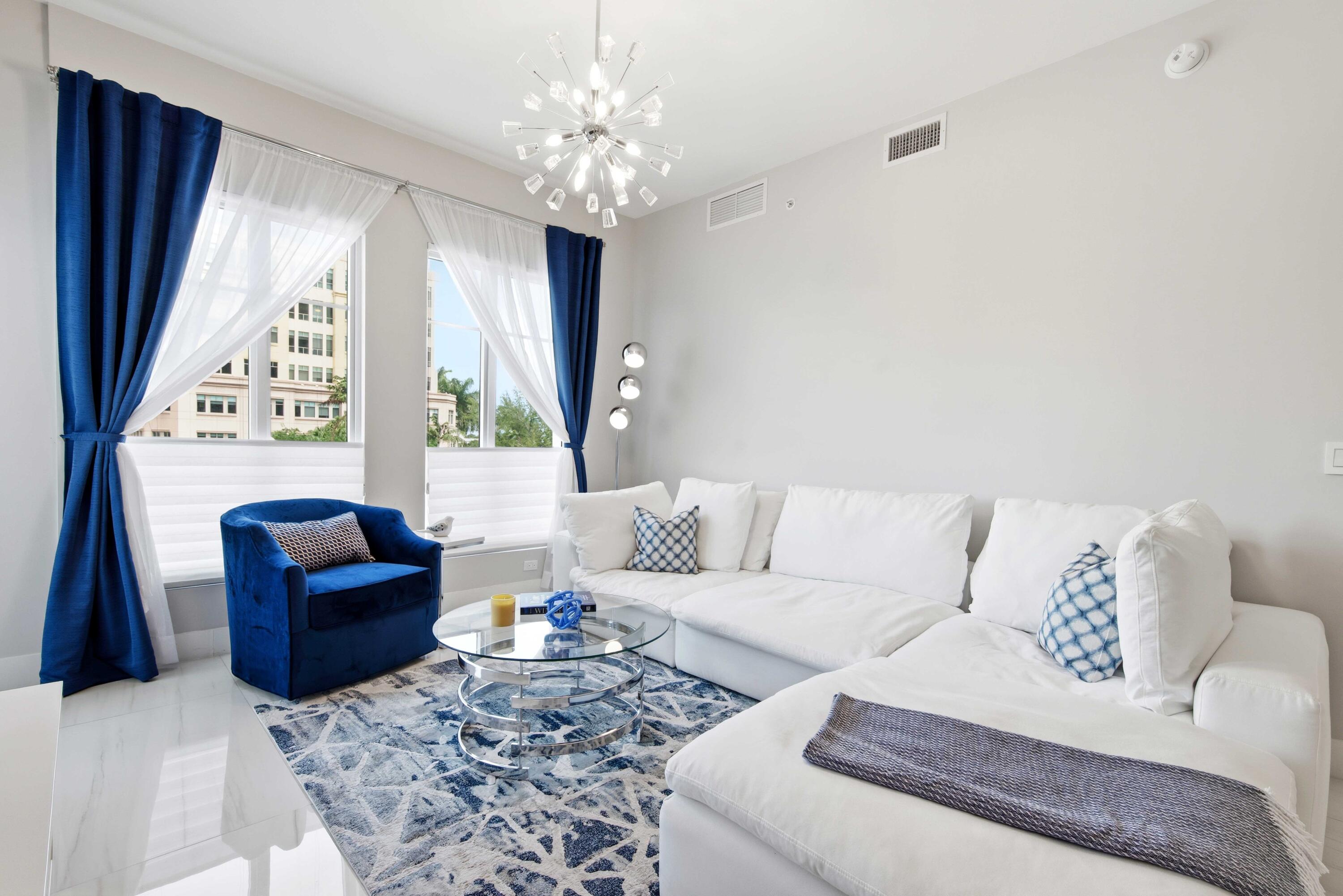 155 East Boca Raton Road, Unit 313 Boca Raton, FL 33432 - Photo 19 of 72 a living room with furniture and a chandelier