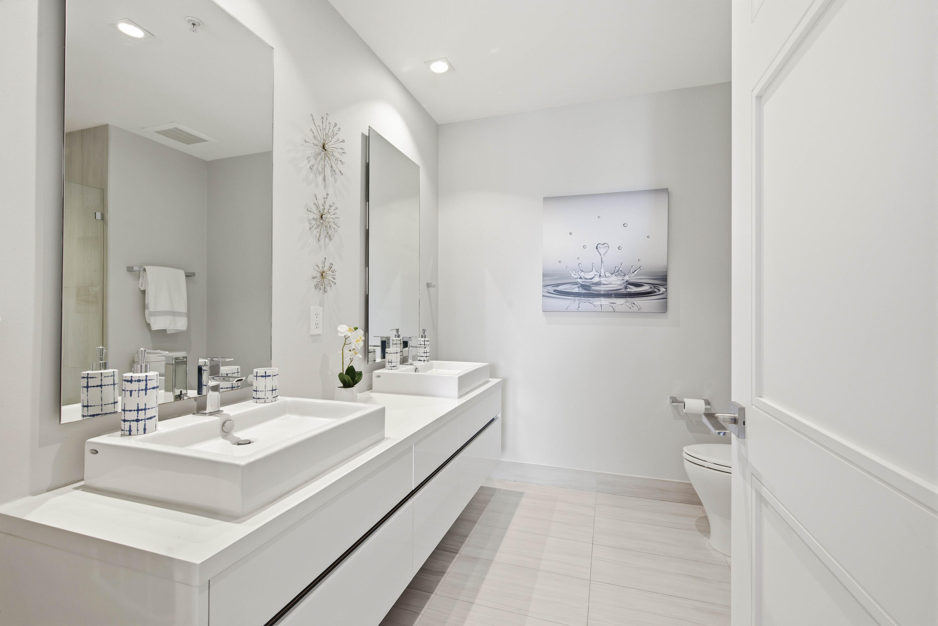 155 East Boca Raton Road, Unit 313 Boca Raton, FL 33432 - Photo 34 of 72 a bathroom with a double vanity sink mirror and toilet