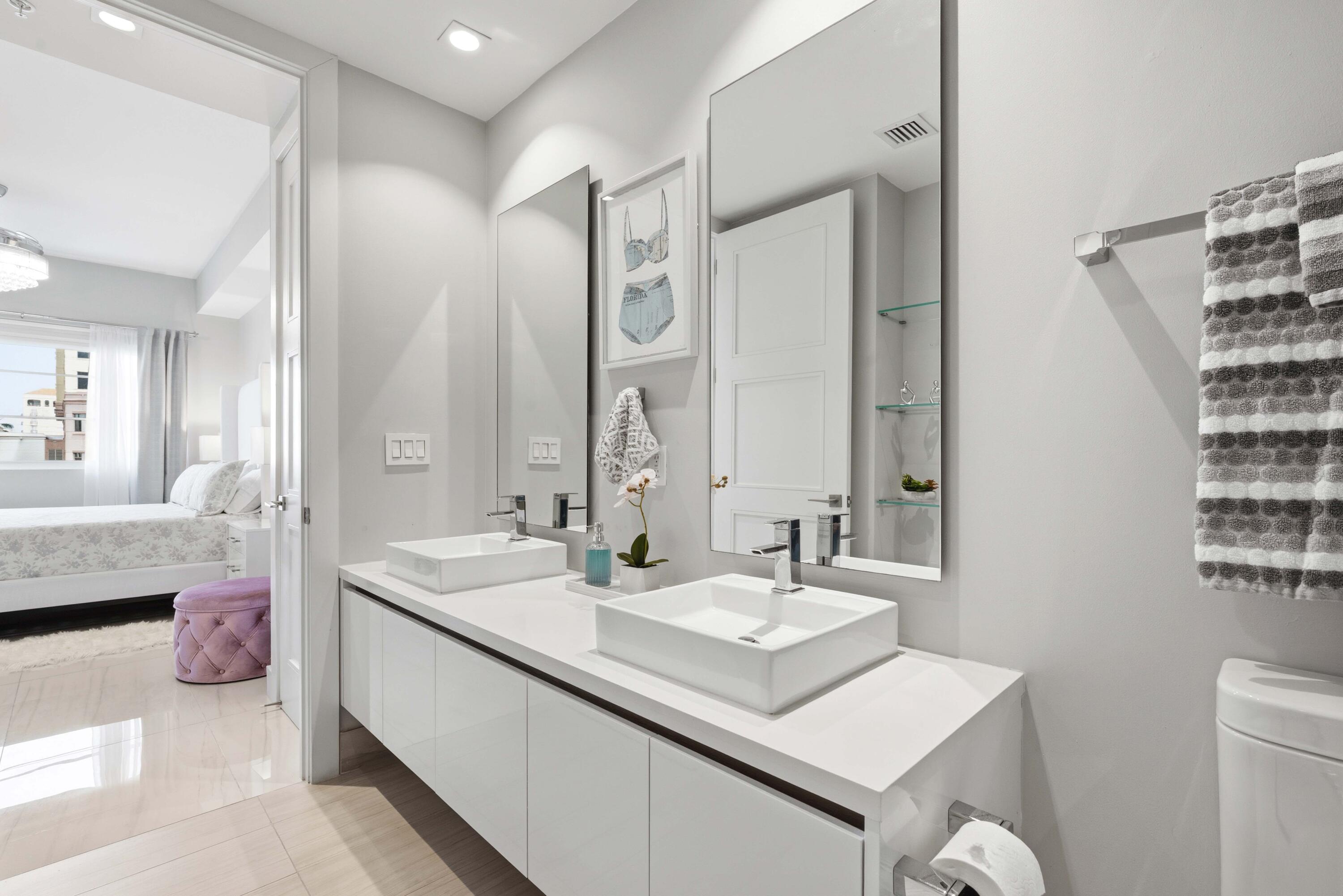 155 East Boca Raton Road, Unit 313 Boca Raton, FL 33432 - Photo 46 of 72 a bathroom with a double vanity sink mirror and toilet