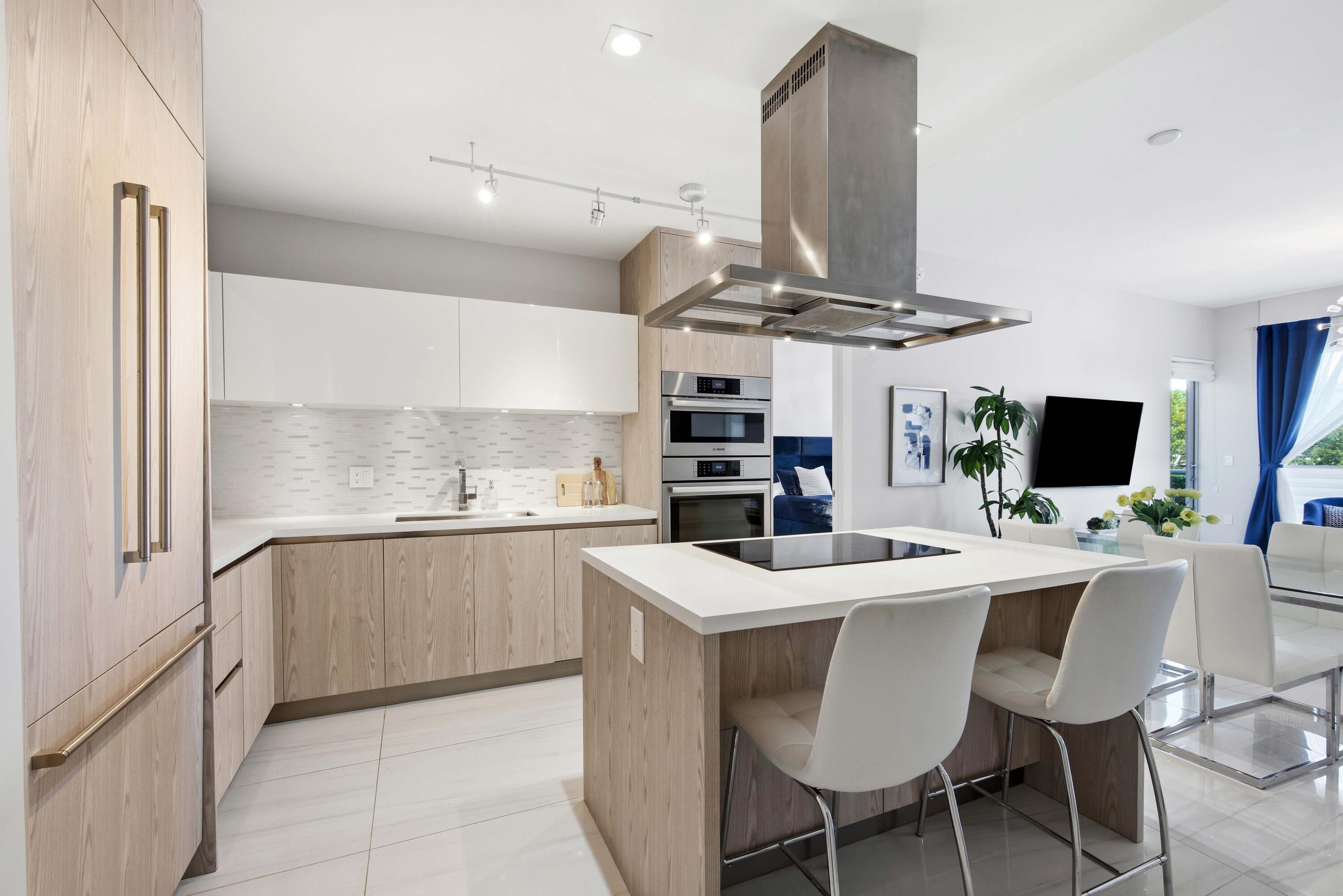 155 East Boca Raton Road, Unit 313 Boca Raton, FL 33432 - Photo 5 of 72 a kitchen with stainless steel appliances a dining table chairs and a sink