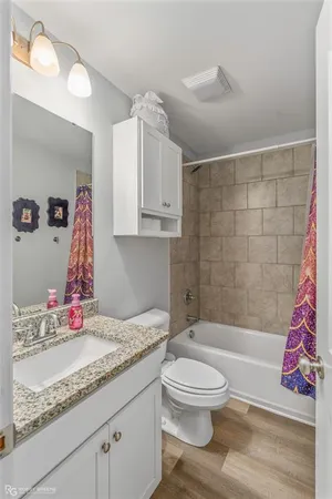 a bathroom with a granite countertop sink toilet and shower