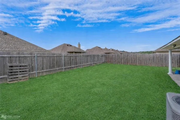 a view of a yard with wooden fence