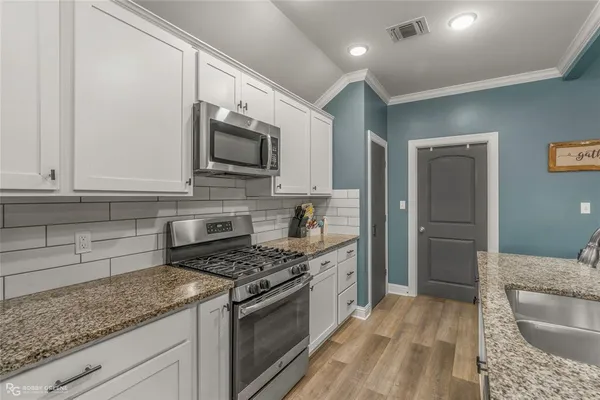 a kitchen with granite countertop cabinets stainless steel appliances and a counter space
